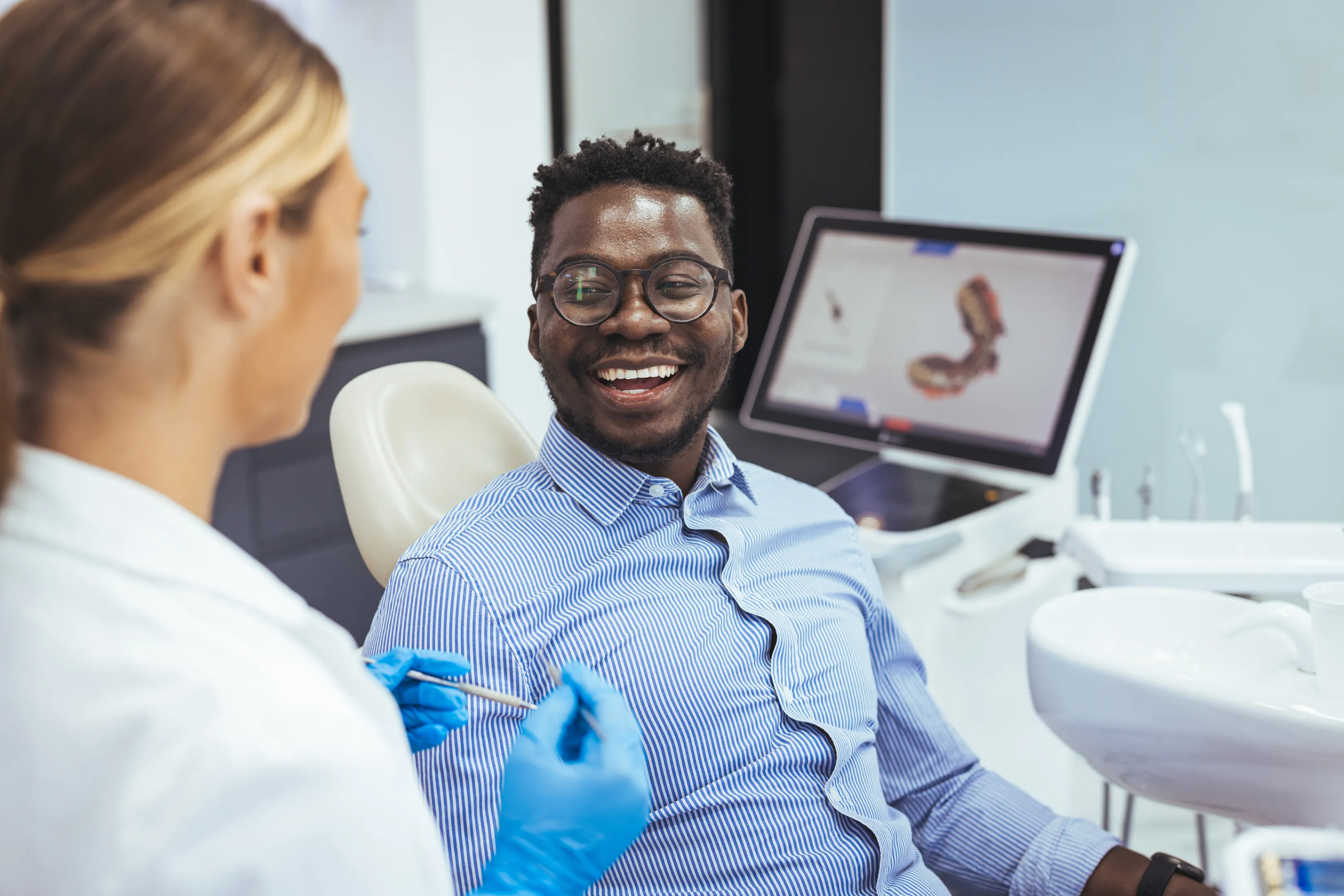 Smiling patient chatting with their dentist at Glassell Dental