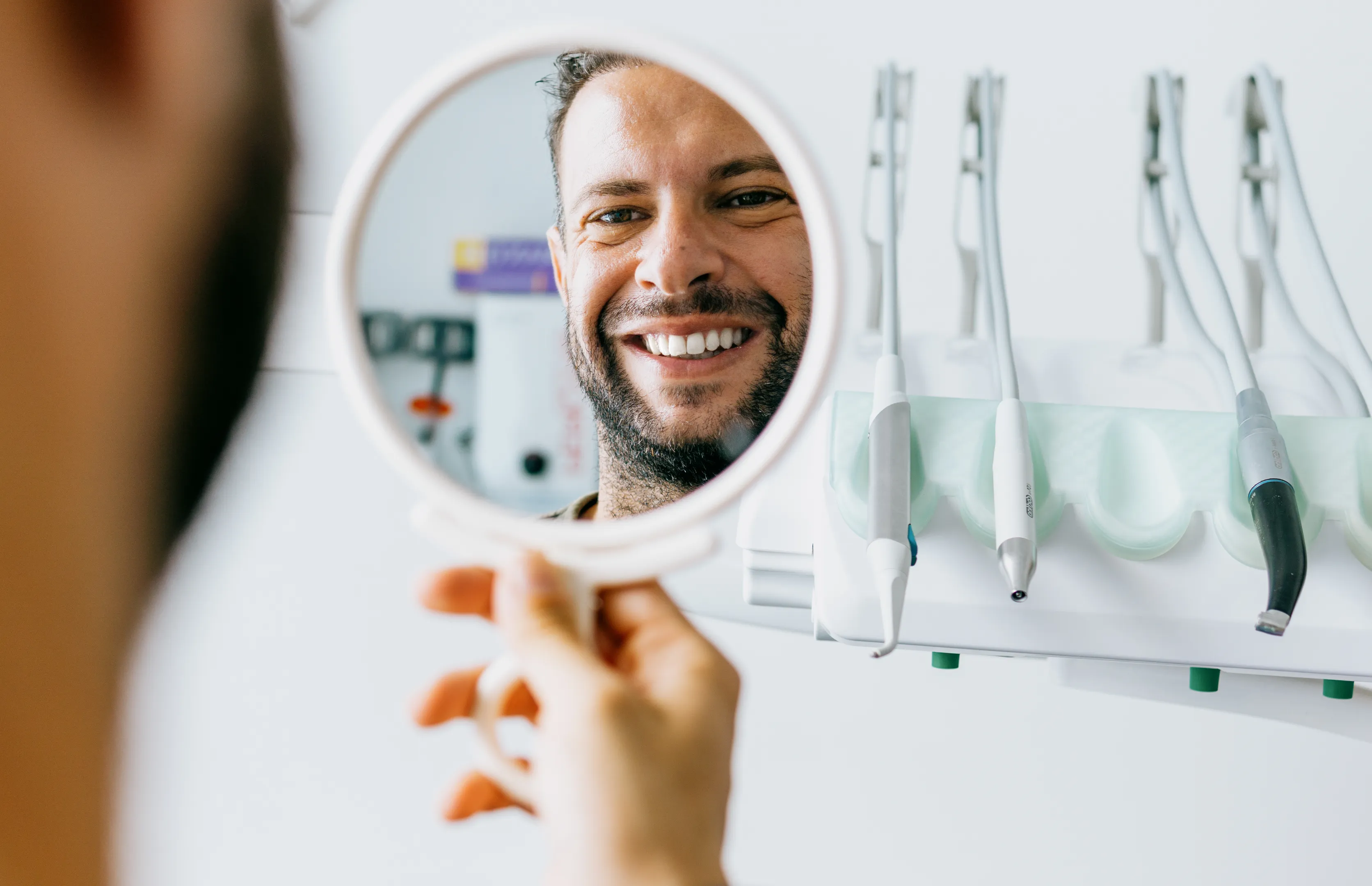 Patient admiring their smile in a mirror after treatment