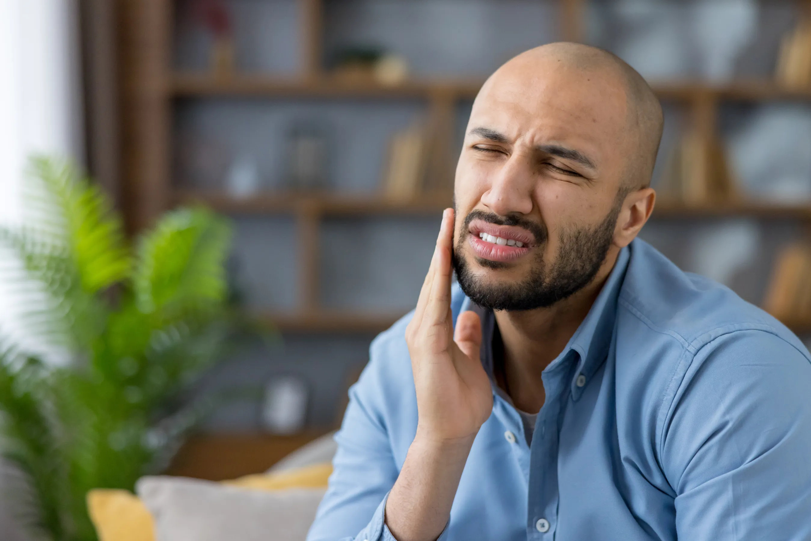 Man with sudden tooth pain in need of emergency dental care