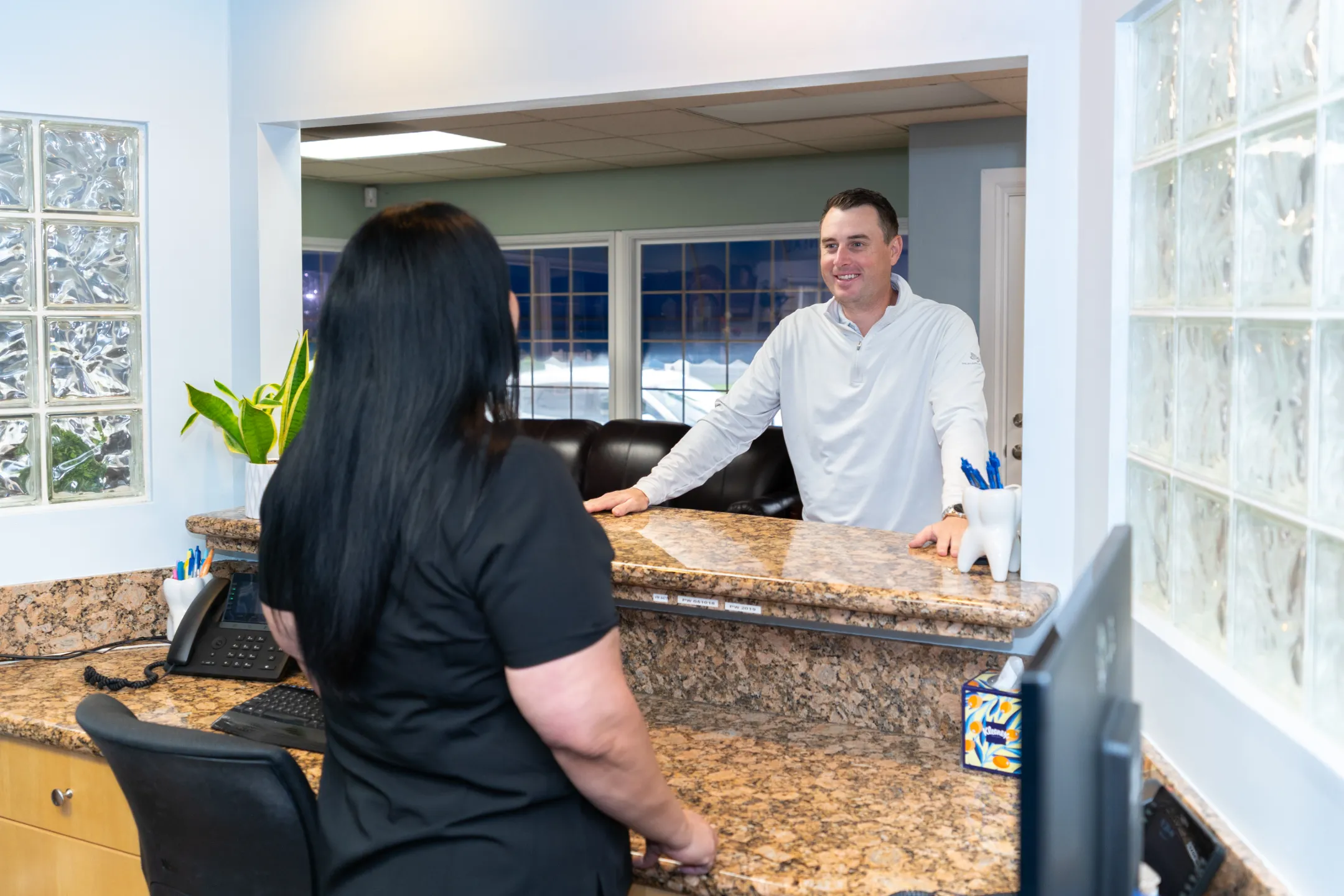 Happy patient framing their healthy smile with their hands