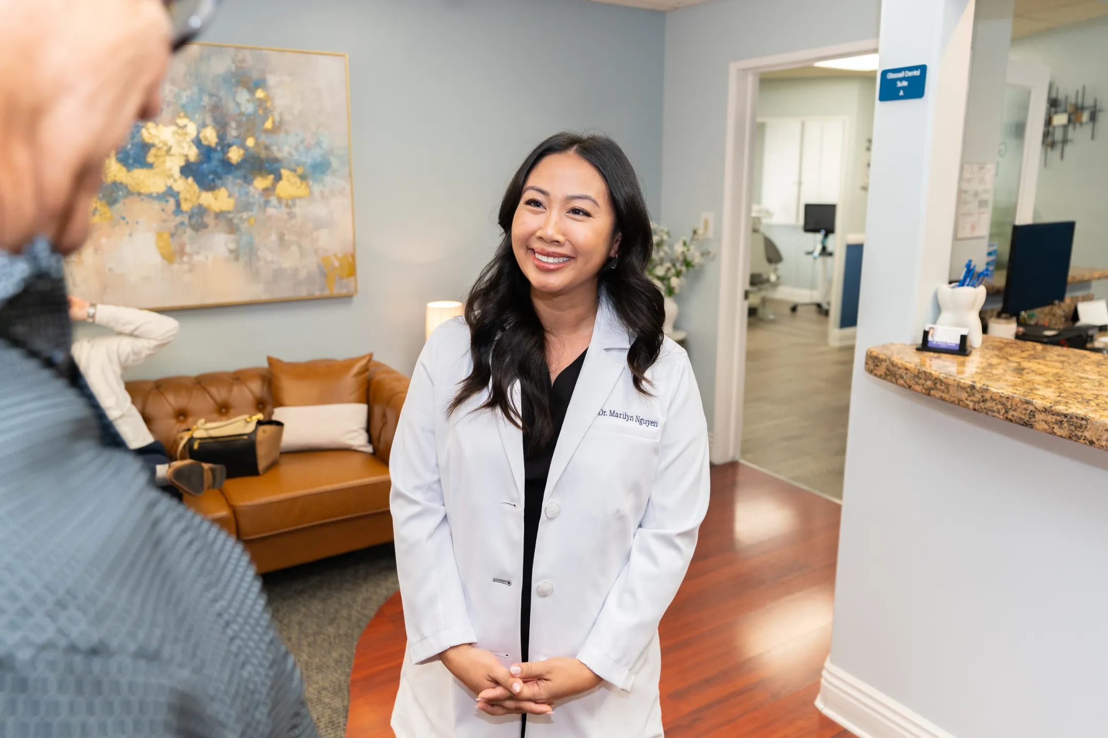 Dr. Marilyn Nguyen speaking with a patient in the Glassell Dental waiting room