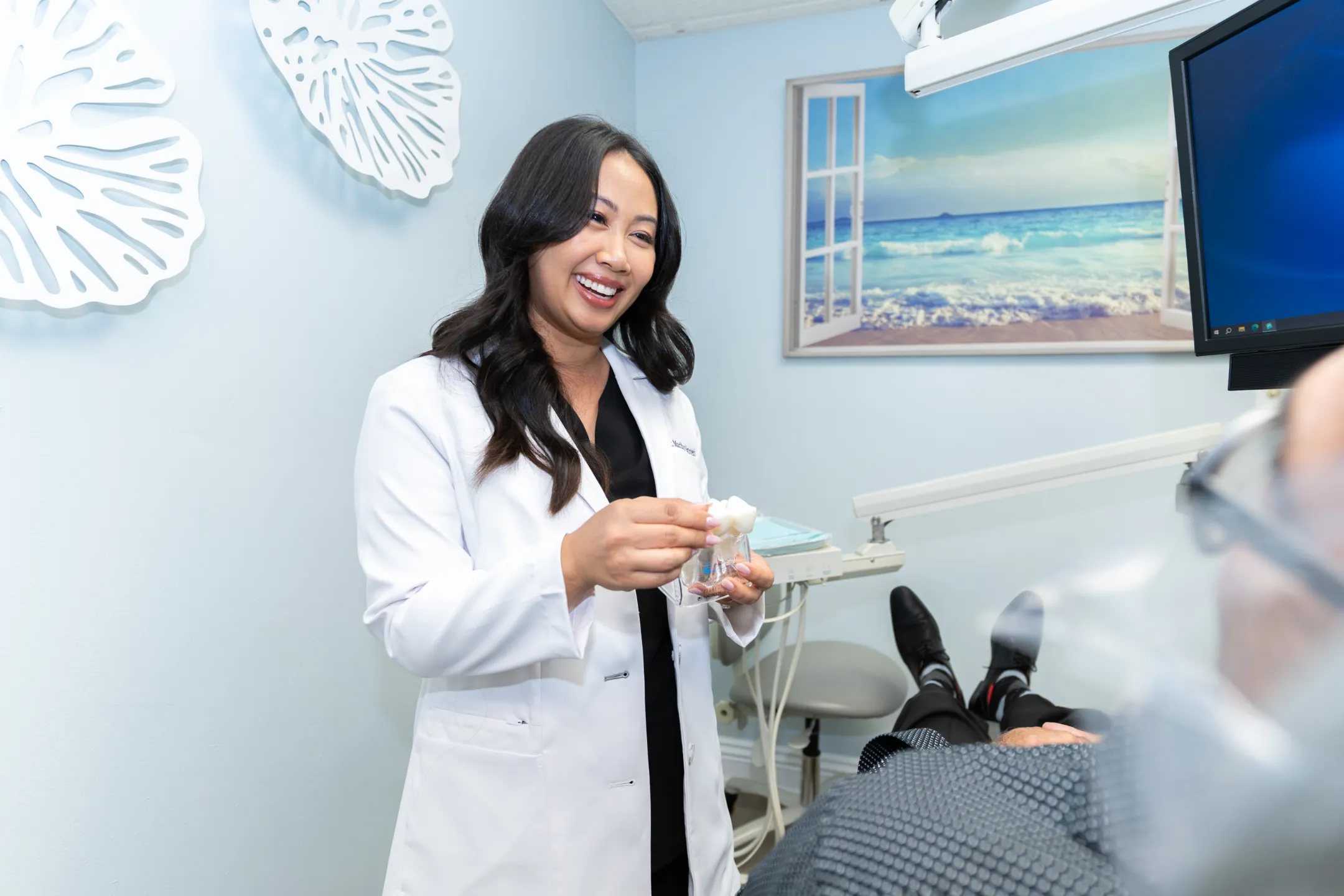 Dr. Nguyen showing a patient a clear aligner and tooth model